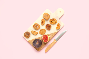 Board with sweet dried figs and fresh fruits on pink background