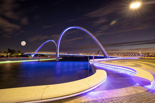 Stunning beautiful sunsetting cityscape at Elizabeth Quay bridge with fall moon at the background Perth city CBD, Western of Australia  