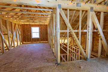 An unfinished house with wooden framing beams in construction work progress view