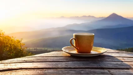 Poster Cup of hot tea placed on an old wooden floor with a beautiful mountain view. The sun is rising © Thachakrit