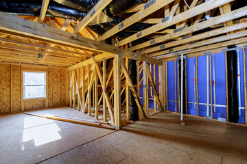 Unfinished house construction with wooden framing beams work in progress view