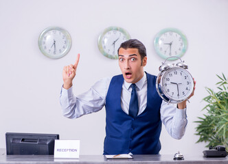 Young man receptionist at the hotel counter