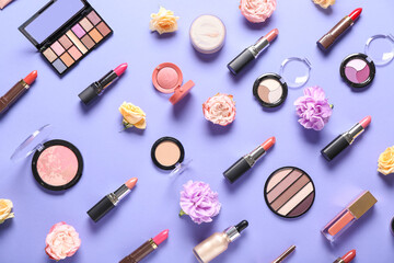 Lipsticks with eyeshadows palettes and flowers on lilac background
