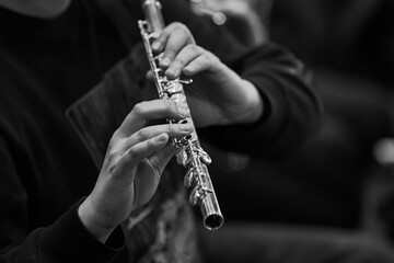 Hands of a musician playing the flute in black and white 