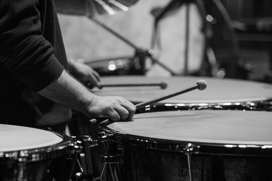 Hands of a musician playing the timpani in an orchestra close-up in black and white
