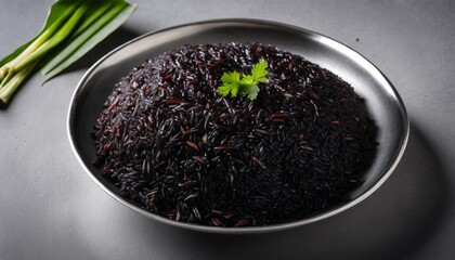 A bowl of black rice with a green herb on top