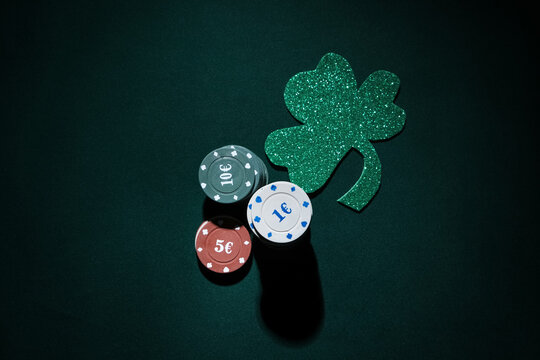 Poker chips with lucky clover on dark green background. St. Patrick's Day celebration