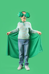 Funny girl with face painting, cape and clover shaped novelty glasses on green background. St. Patrick's Day celebration