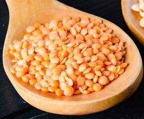 The spoons filled with uncooked lentil for soup