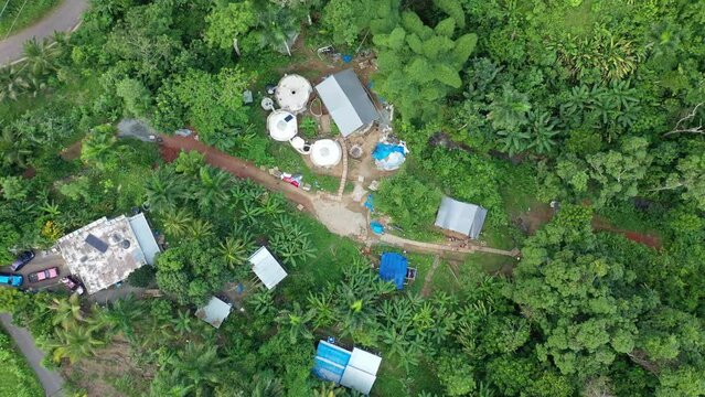 Drone shot over the Earthship of Aguada, Puerto Rico surrounded by beautiful vegetation