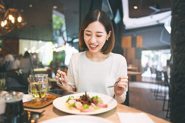 Fototapeta premium Asian woman eating healthy food at cafe restaurant city break on weekend lifestyle