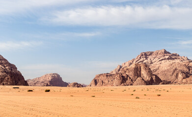 Fototapeta na wymiar Unique beauty of high mountains in endless sandy red desert of Wadi Rum near Amman in Jordan