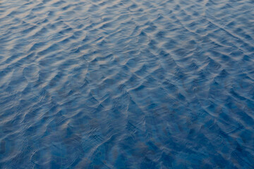 Water surface with waves on water surface wave effect You can see the blue square tiles at the bottom of the pool.