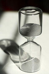 デスク上の砂時計　印象的な光と影とガラスの反射