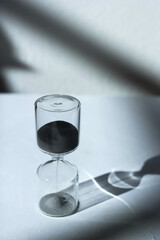 デスク上の砂時計　印象的な光と影とガラスの反射