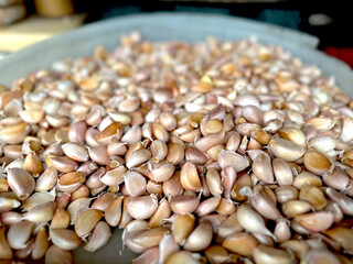 Closeup of garlic cloves selling on a tray at a fresh produce market. 