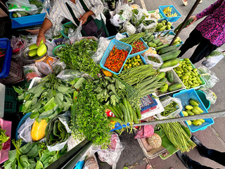 Fresh Herbs, Greens, Vegetables, Spices Selling at an Outdoor Food Market, Thailand. Traditional Ingredient from Southeast Asia Cuisine. Woman, Man, Street Vendors, Stall. 