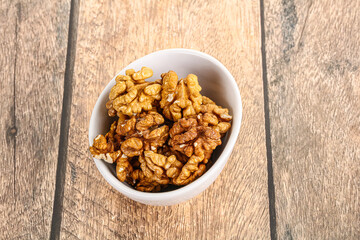 Cracked unshelled walnut in the bowl