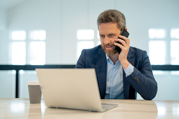 Business office interior. Businessman chatting phone online in office. Business man in suit using phone. Office worker solves cases on phone. Office manager talk phone. Ceo manager using smartphone.