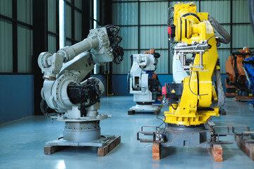 Industrial robot arms for various types of automated welding are placed in modern automobile factory.