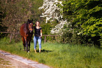Young woman with horse in spring in nature.