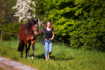 Young woman with horse in spring in nature.