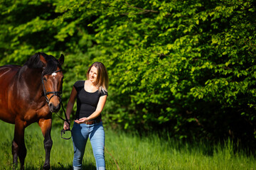 Young woman with horse in spring in nature.