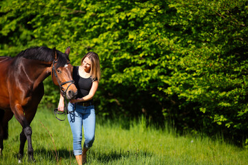 Young woman with horse in spring in nature.
