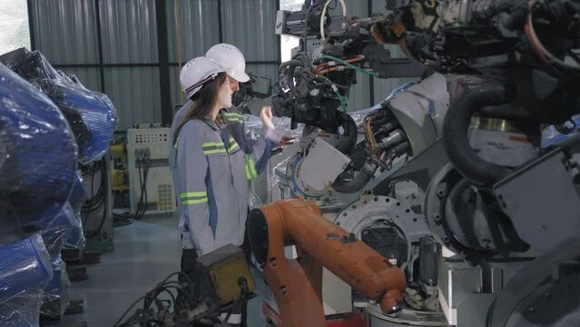 Caucasian Engineer Examining Automated Robotic Arm