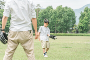 Obraz premium 新緑の公園で野球をする男兄弟とパパ・父親（家族・キャンプ・アウトドア） 
