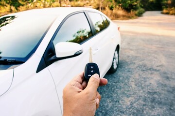 Hand holding button on the remote control car key.