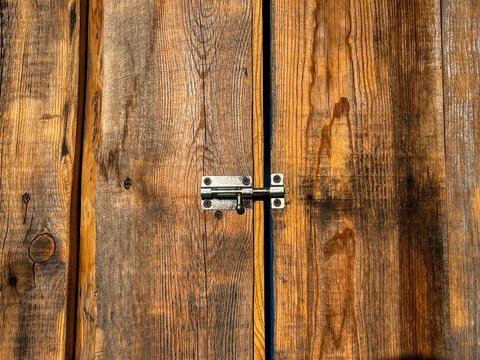 Wooden barn door closed on metal latch