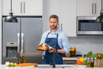 Chef man in in cook apron cooking seafood in the kitchen. Restaurant menu concept. Cook in chef apron hold seafood. Portrait of chef man hold seafood in kitchen.