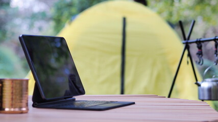 Tablet screen placed on camping table For adding text