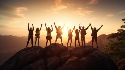 Joyful silhouette of a group of people jumping in the air against a stunning mountain sunrise
