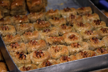 Traditional Turkish dessert, walnut birds nest baklava or bulbul yuvasi whole nuts in fresh phyllo dough at a local pastry shop in Istanbul, Turkey