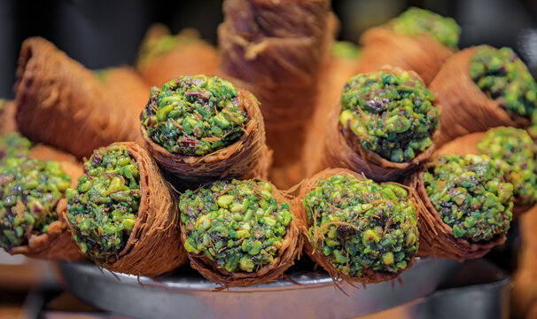 Traditional Turkish dessert, fresh crispy layered pistachio baklava or ballorieh in a cone at a local pastry shop in Istanbul, Turkey