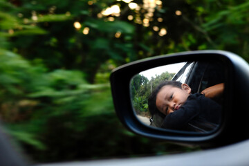 Face Of Boy Reflected In Car Rearview Mirror