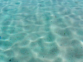 Turquoise clear sea water showing clean sand below the surface.