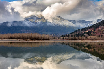 Reflection of Snowy mountains in the Fraser River at Island 22 in Chilliwack, Canada