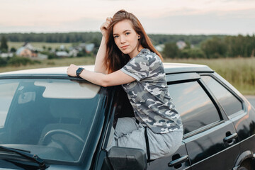 pretty girl sticks out of the car window. sexy girl and car. young car driver