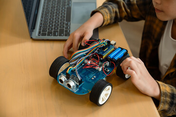 Little child doing robot learn online with car toy technology of robotics in house, Programing and STEM education concept.