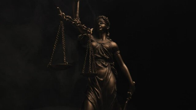 vertical video, concept of balance illustrated by blindfolded Justitia goddess with scale in her hands with smoke and red lights 