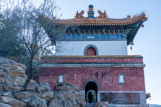 Ancient Chinese guard tower gate on top of the hill at the highest section of an ancient palace complex with two vertical sections and pale color combination of white and pink.