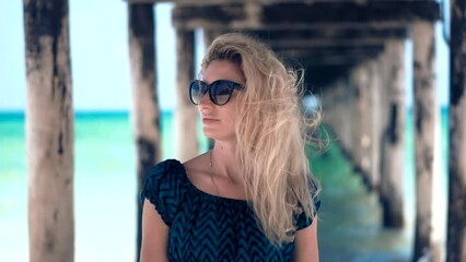 Girl delights in stroll along sandy beach of tropical coast her hair billowing in wind