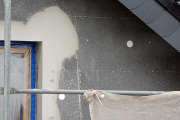 A wall of a house covered with EPS graphite polystyrene boards for thermal insulation, a window...