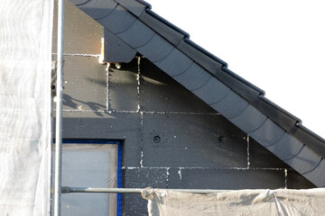 A wall of a house covered with EPS graphite polystyrene boards for thermal insulation, a window...