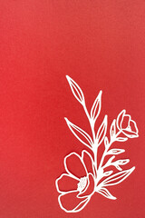 Carve of white paper flower and leaves with copy space on a red background.