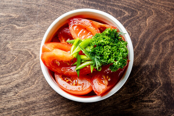 red pickled sliced tomatoes in a bowl