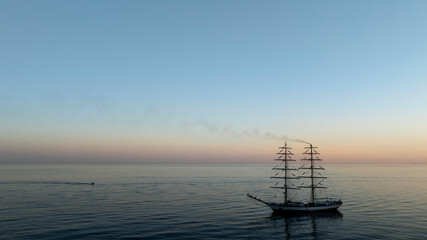 bonito atardecer en el mar junto a un barco velero